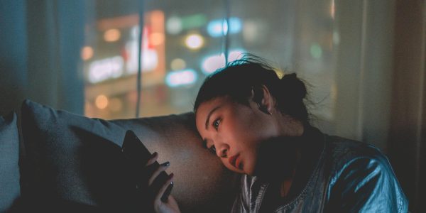 Young girl looking at her cellphone in a dark room